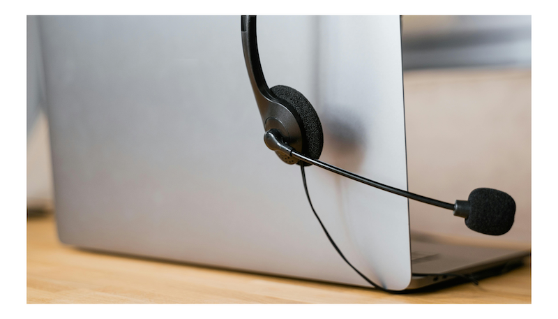 Close-up of customer support headset resting on a laptop
