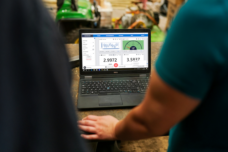 Technicians using MultiGage software on a laptop for real-time industrial measurement and monitoring